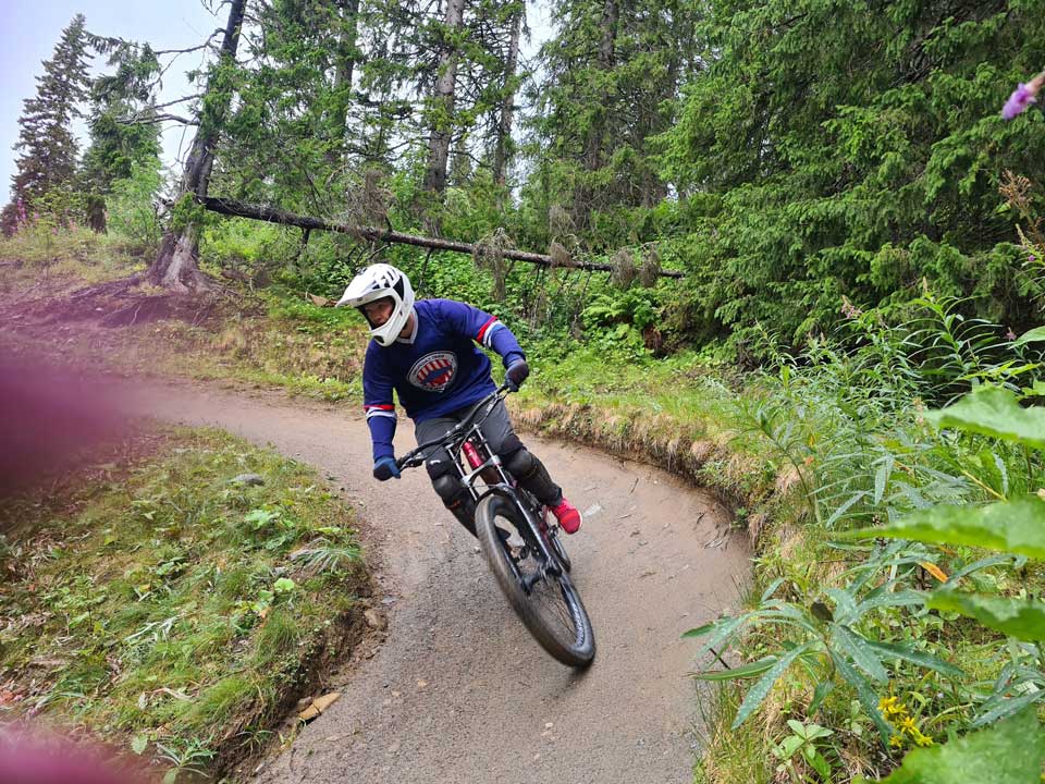 Guy cycles downhill.